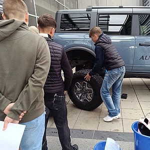 Schüler beim Reifenwechseln