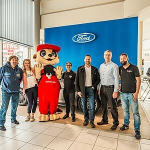 Maskottchen Schraubi mit Team