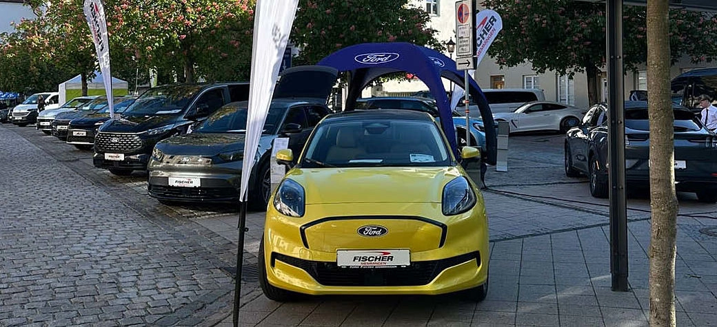 Aufnahme von aufgereihten Autos mit gelben Auto im Vordergrund