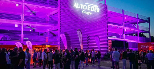 Außenansicht vom Event bei Nacht mit lila Beleuchtung