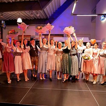 Teilnehmer heben Blumenstrauß in die Luft