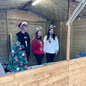 Drei Menschen stehen in einer Hütte 